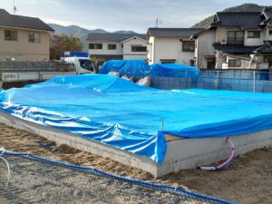 新築住宅の土台敷き施工の様子　ブルーシートで雨除け